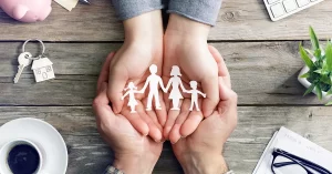 A cutout family held by a couple's hands symbolising protecting your assets with Dixon & Co Lawyers, Property Law services.